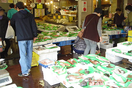 鮮魚売場に並べられた新鮮な魚介類を購入するお客様